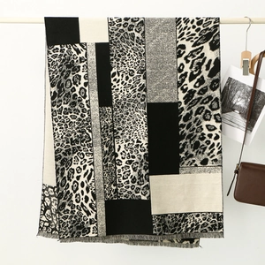 Detail view of stylish leopard print scarf with geometric color blocks and fringe trim