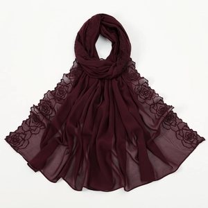 Detail view of burgundy chiffon scarf featuring delicate rose embroidery and elegant hem.
