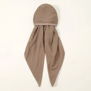 Close-up of brown turban hat fabric with shimmering sequins and soft pleated texture