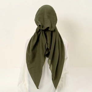 Detail view of the back of a dark green elastic hijab with a soft drape and light texture