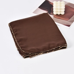 Close-up of deep brown chiffon hijab scarf with golden beaded chain edge detail