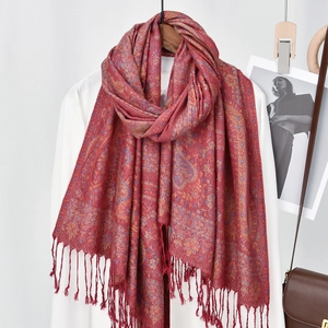 Detail view of the bohemian paisley pattern and fine fringe on this red tassel shawl