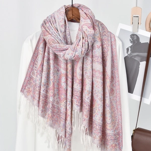 Close-up of pink and purple paisley patterns with white fringe on a polyester scarf