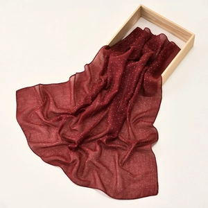 Deep red chiffon scarf with shimmering rhinestones displayed on a minimal wooden tray