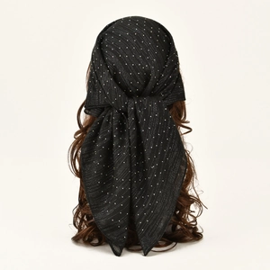 Close-up of black rhinestone headscarf with shimmering star patterns on hair