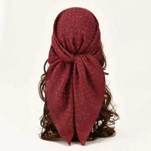 Close-up of knotted burgundy polka dot scarf with rhinestones on wavy hair model