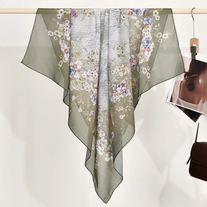Elegante pañuelo cuadrado de poliéster con flores colgado en una barra de madera decorativa
