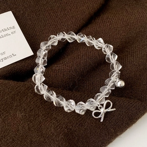 Elegant beaded bracelet with faceted clear crystals and stylish metal bow charms