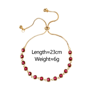 Detail of adjustable gold-tone box chain bracelet with 13 faceted red round gemstones