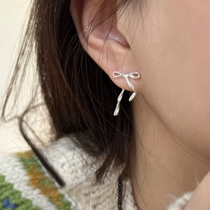 Elegant silver bow earrings with long tassels shown on a model for a chic look