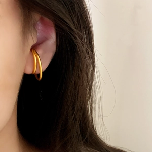 Minimalist double-layered matte gold ear cuff jewelry worn on female ear cartilage