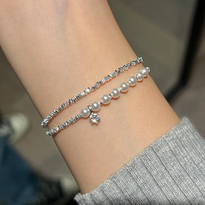 Elegant double-layer bracelet with pearls and irregular silver beads on a model wrist