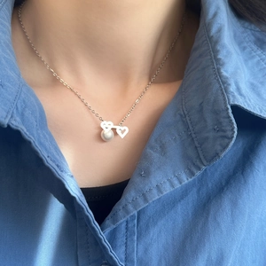 Elegant silver necklace featuring interlocking hollow hearts and a lustrous white pearl pendant