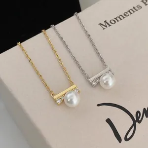 Elegant pearl pendant necklace featuring gold and silver chains with zircon accents