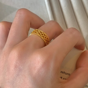 Elegant gold hollow mesh open ring with beaded edges worn on a finger for a minimalist look