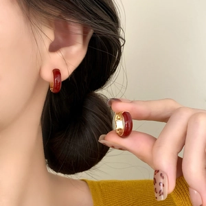 Chic burgundy enamel gold hoop earrings worn by a model for a sophisticated look
