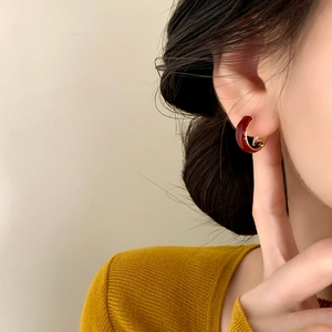 Elegant C-shaped red enamel hoops with gold plating shown on a model for daily wear