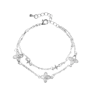 Double-layered silver bracelet featuring three zircon-studded clover charms on a white base
