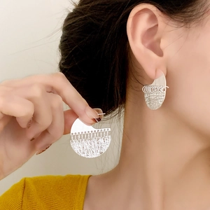 Elegant silver layered hoop earrings with smooth and mesh texture on female model