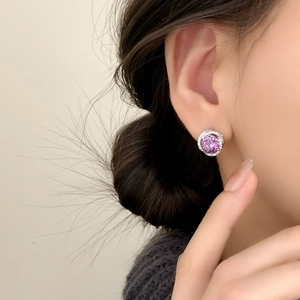 Elegant halo stud earrings with purple gemstone and white zircon on female model