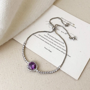 Close-up of elegant purple gemstone bracelet with adjustable silver chain and crystal halo