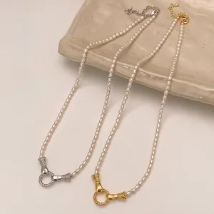 Elegant gold and silver pearl necklaces with OT clasp on a white ceramic plate
