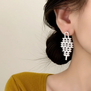 Silver geometric tassel earrings with zircon accents worn by a model in a side view