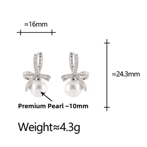 Détail de boucles d'oreilles nœud argenté avec zircons et perles premium de 10mm