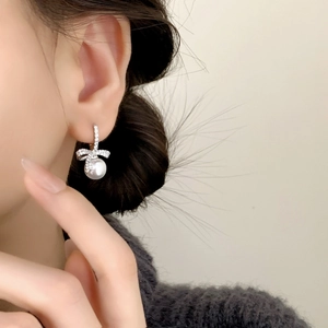Boucles d'oreilles nœud en argent avec zircons incrustés et perles blanches élégantes