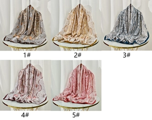 Macro detail of five paisley printed silk scarves in various colors and smooth finish