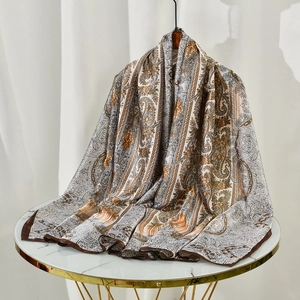 Detail of vintage paisley print scarf with silk texture and elegant brown border