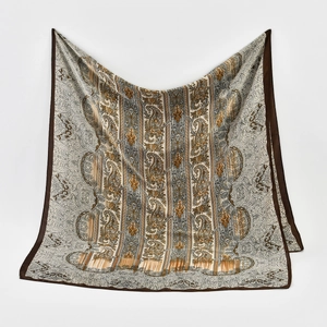 Macro detail of silk-like paisley pattern scarf with rich champagne and gold texture