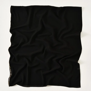 Detail of black chiffon scarf with elegant gold bead fringe and lightweight texture