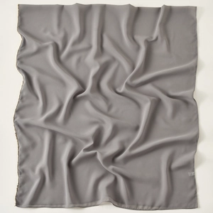 Detailed view of dark grey chiffon scarf with gold beaded edge and soft texture drape