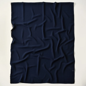 Detail of navy blue chiffon scarf showing light breathable texture and gold glitter trim