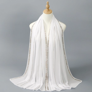 Elegant white chiffon scarf with gold geometric patterns on a mannequin display