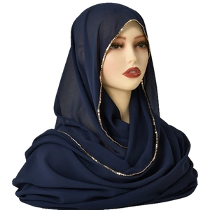 Navy blue chiffon hijab scarf with elegant gold square bead trim on a display head