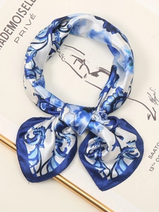 Detail of silk-feel blue floral neck scarf showing satin texture and ornate vine pattern