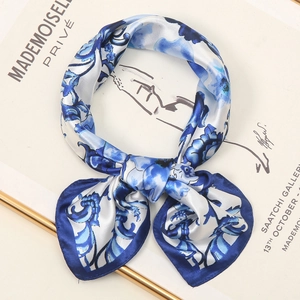 Blue and white floral silk scarf with borders folded elegantly on a fashion book
