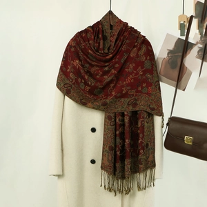 Vista dettagliata dello scialle ricamato paisley rosso scuro con eleganti frange lunghe