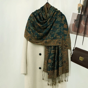 Dettaglio dello scialle paisley verde con frange su un cappotto per un look etnico retrò