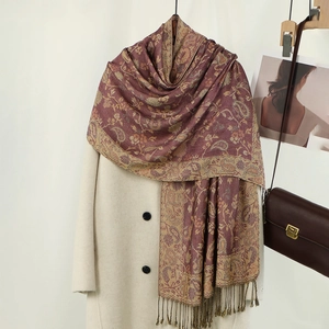 Dettaglio del ricamo paisley e delle frange su uno scialle bordeaux spesso