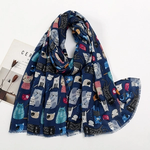 Détail d'une écharpe bleu foncé avec des motifs de chats et des bords effilochés