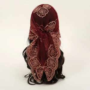 Foulard carré en dentelle rouge foncé avec broderie rose sur une tête de mannequin