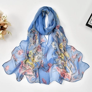 Close-up of blue georgette scarf with elegant floral prints and rolled hem finish
