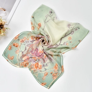Detail of elegant georgette silk scarf with floral patterns and 100% silk label