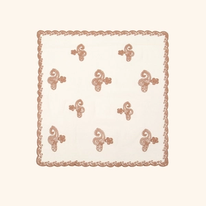 Close-up of intricate paisley embroidery and scalloped edges on a beige square scarf
