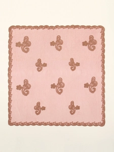 Detailed embroidery and lace edges on elegant pink hijab headscarf fabric