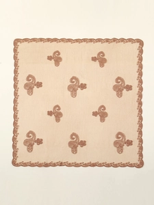 Detail of paisley embroidery and scalloped lace edges on a light brown chiffon scarf