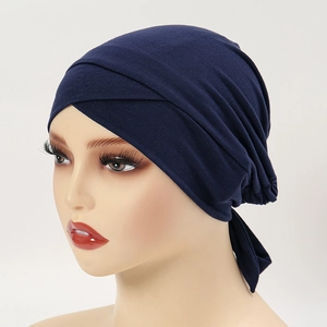 Detail view of navy modal cotton turban hat featuring front cross pleats and tie-back straps